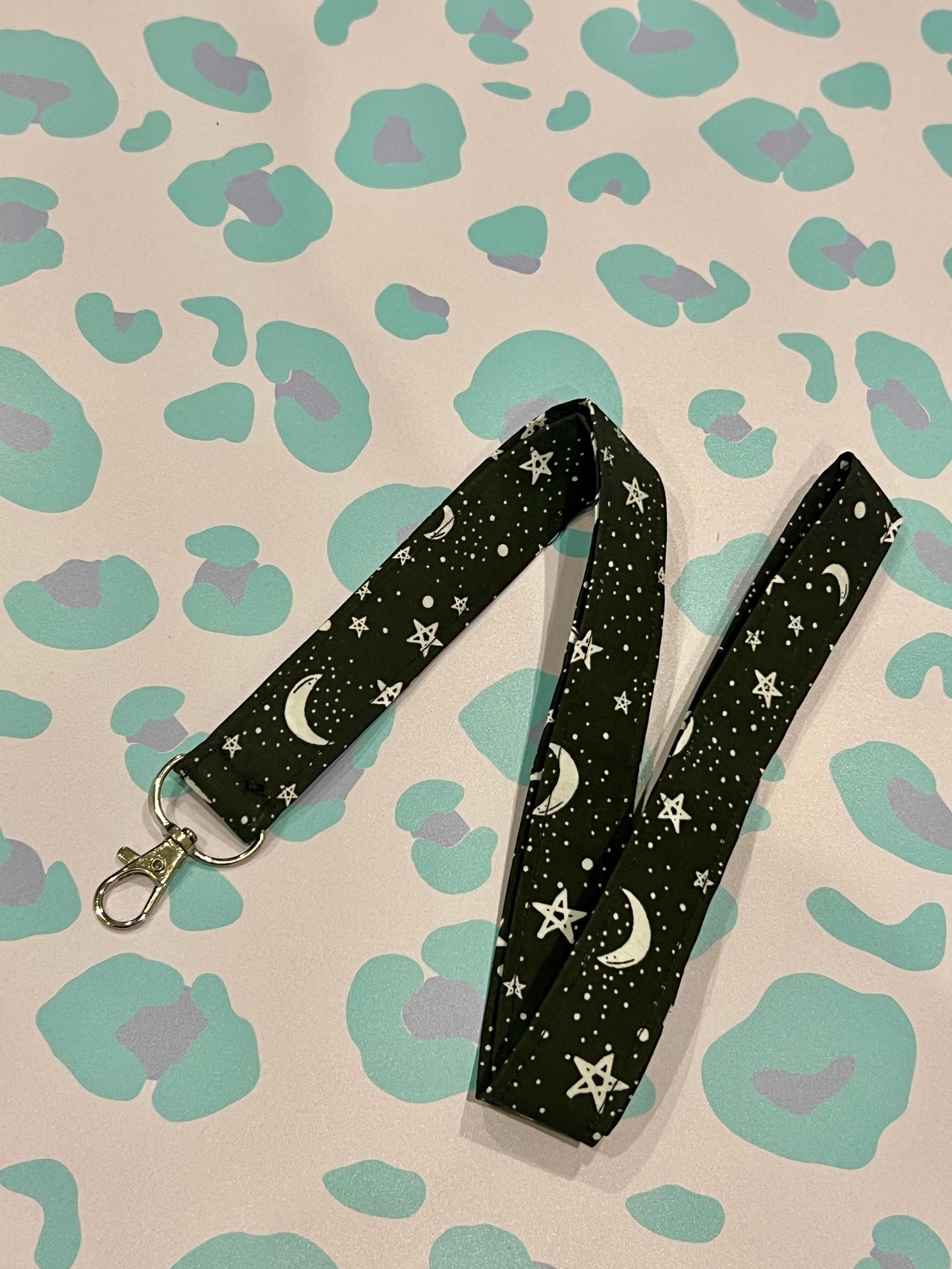 Sew Much Love black fabric lanyard with white stars and crescent moons, silver lobster clasp.