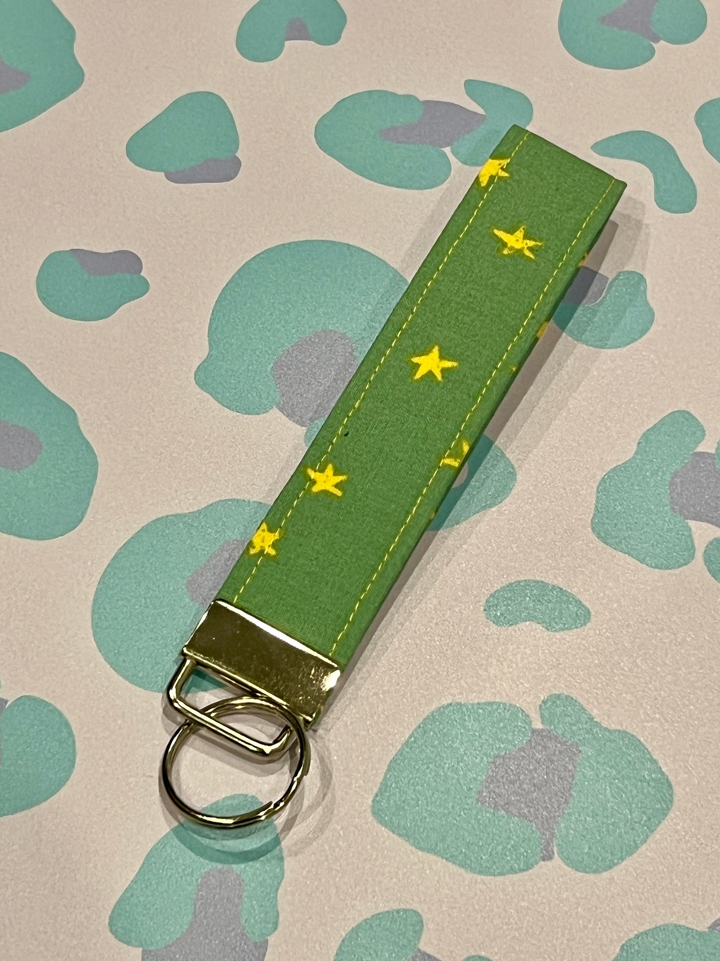 Green keychain with yellow stars on a patterned background