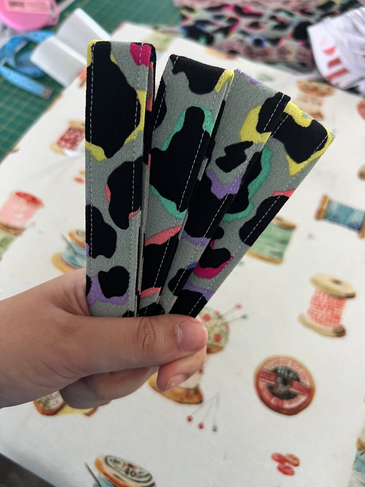 Owner of Sew Much Love holding 4 Khaki Rainbow Leopard Print Wristlet Keychain