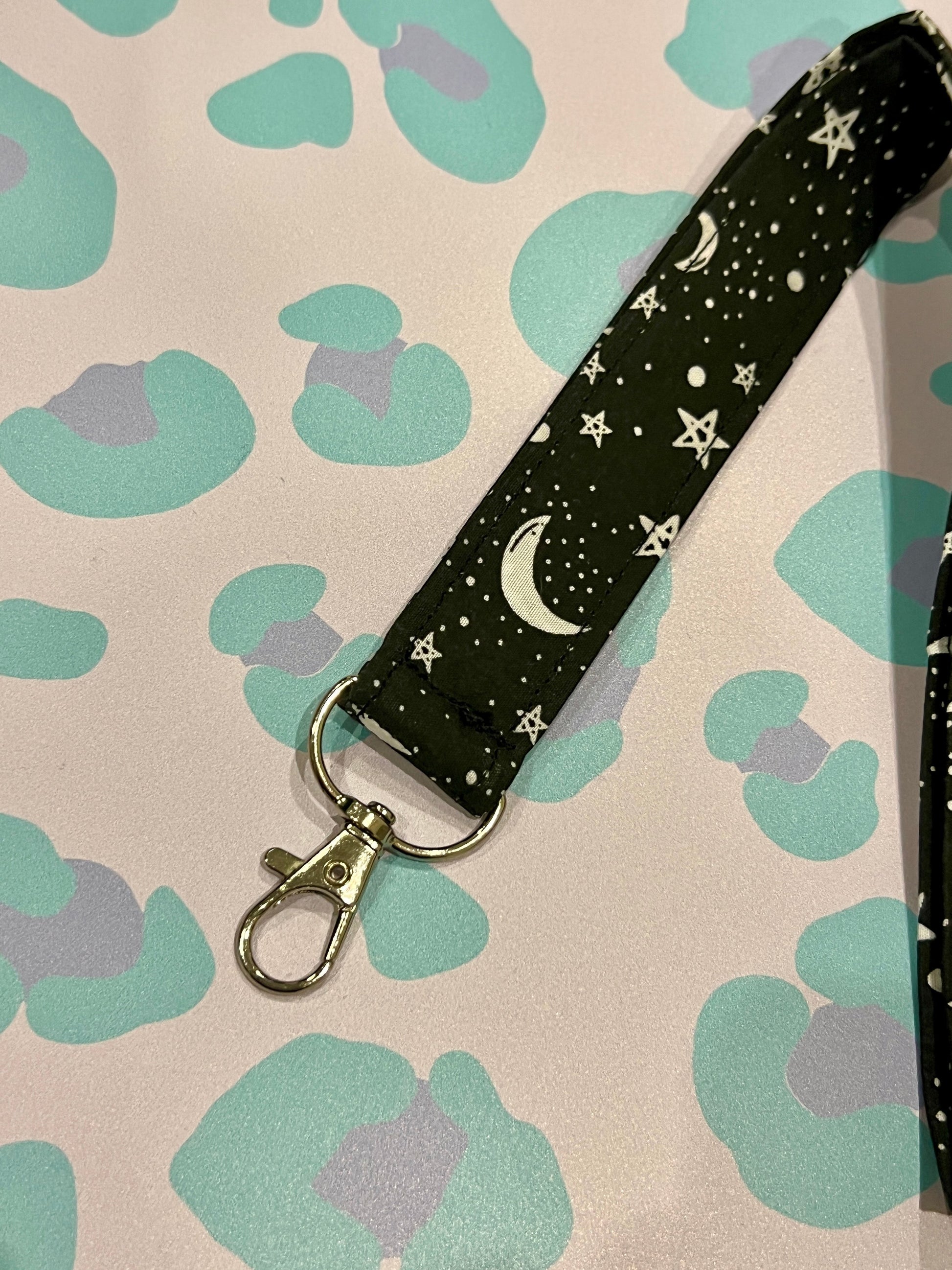 Sew Much Love black fabric lanyard with white stars and moons, silver lobster clasp.