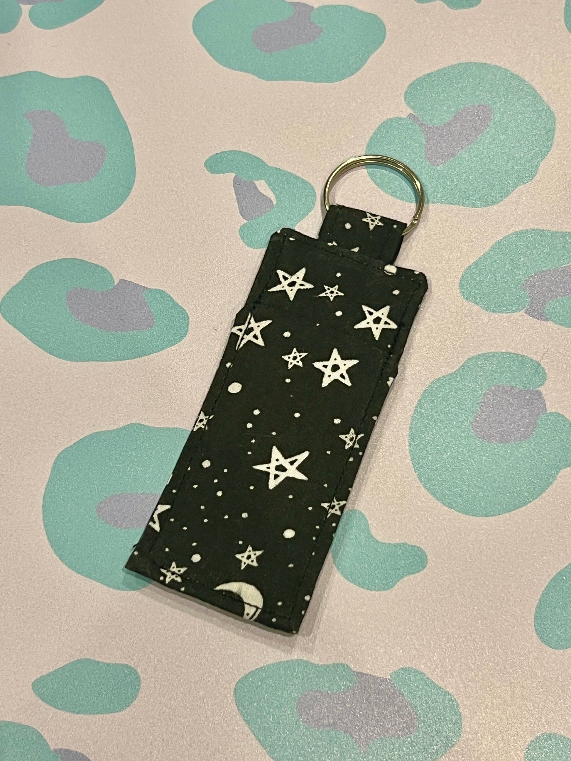 Black keychain with star pattern on a patterned background