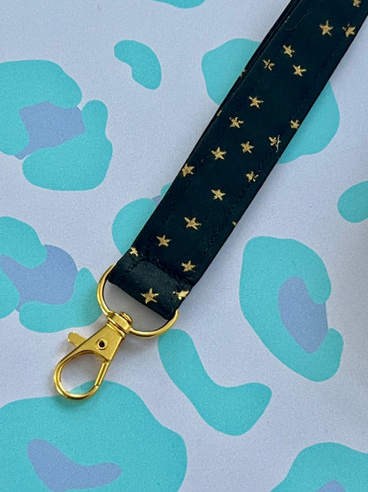 Sew Much Love black fabric lanyard with gold stars and a gold lobster clasp.