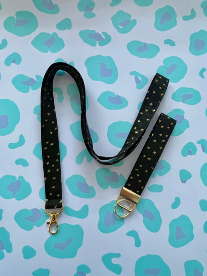 Black lanyard with gold accents on a blue and green patterned background