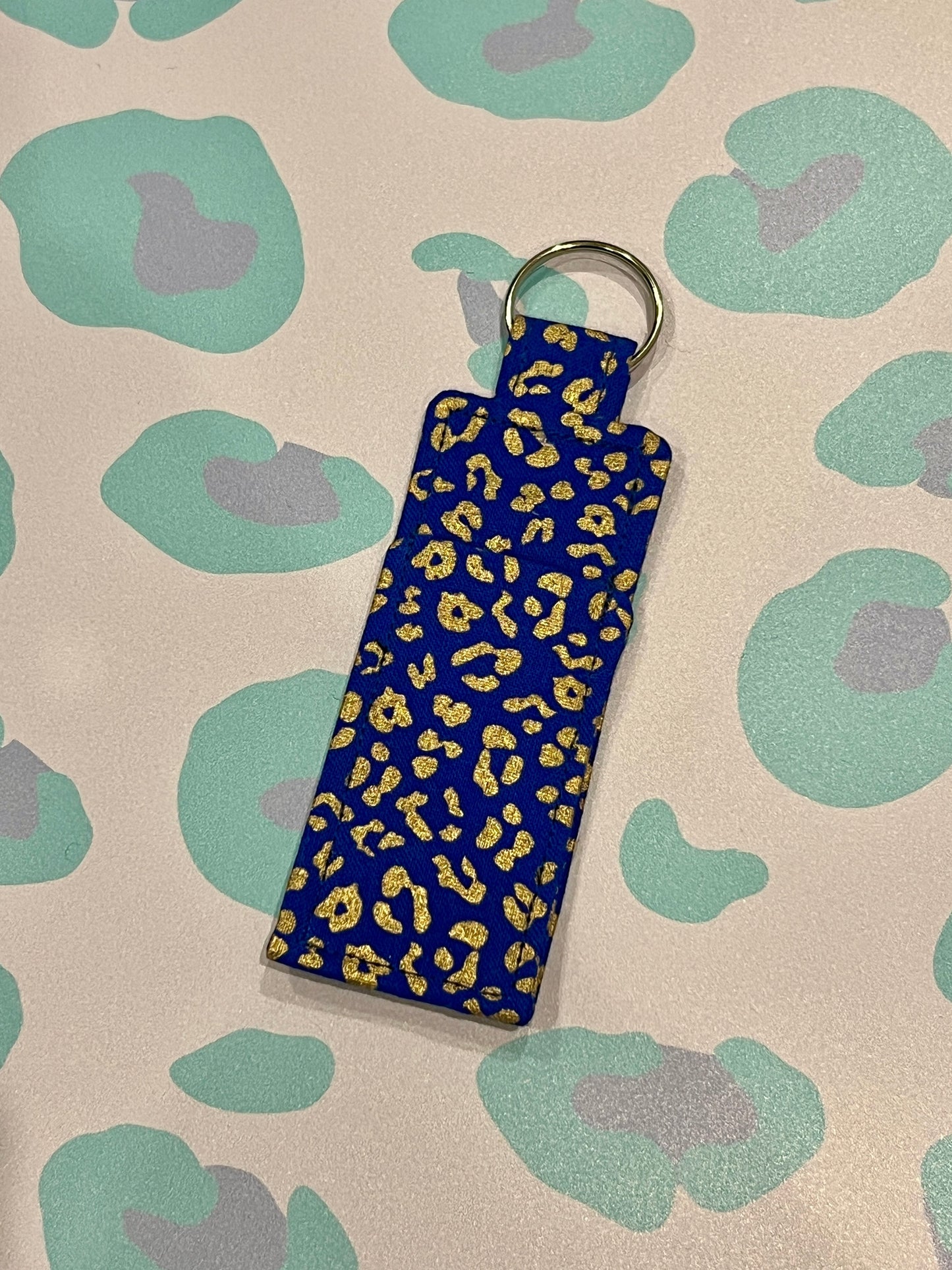Blue keychain with leopard print on a patterned background