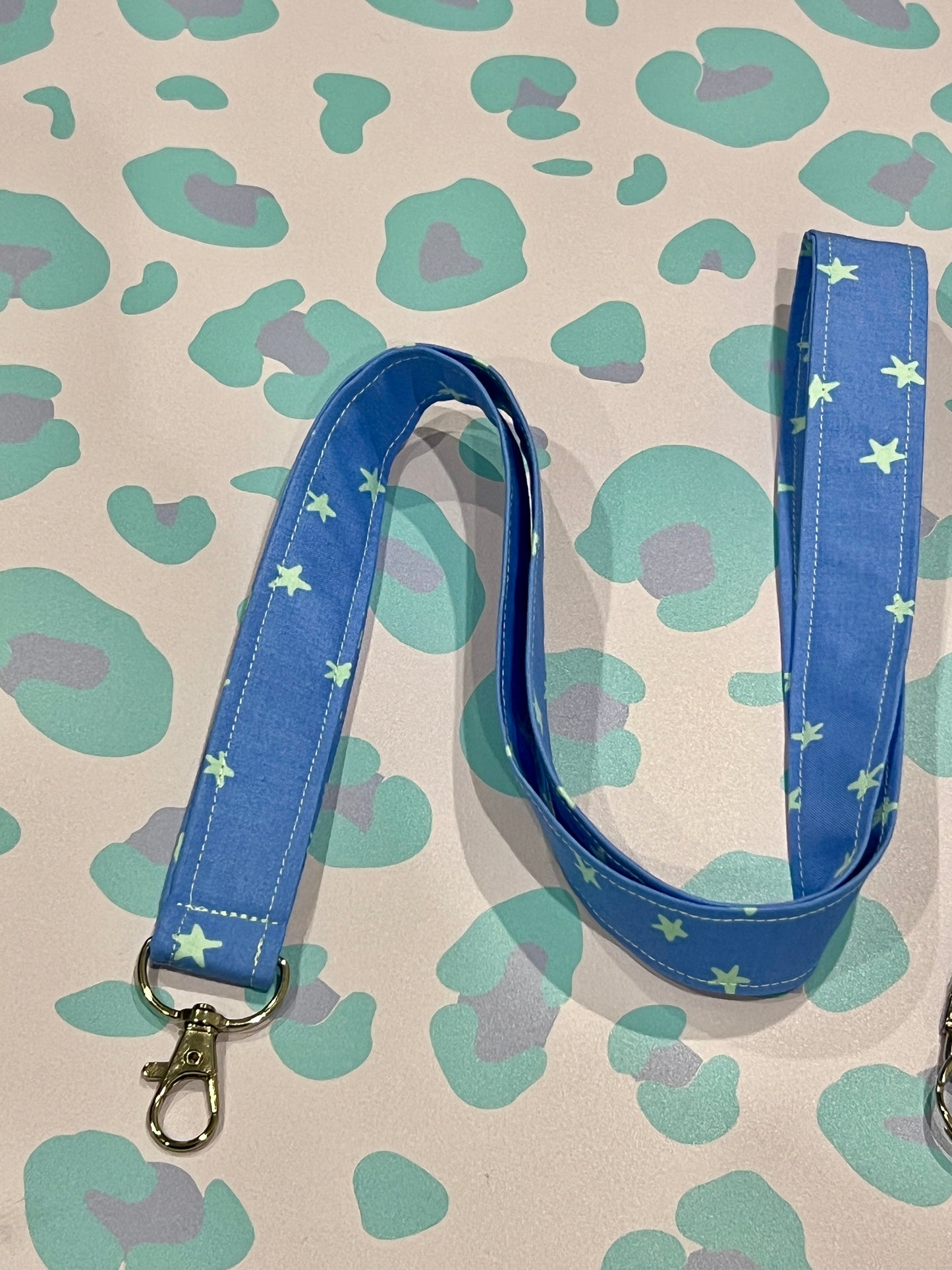 Blue lanyard with star pattern on a patterned background
