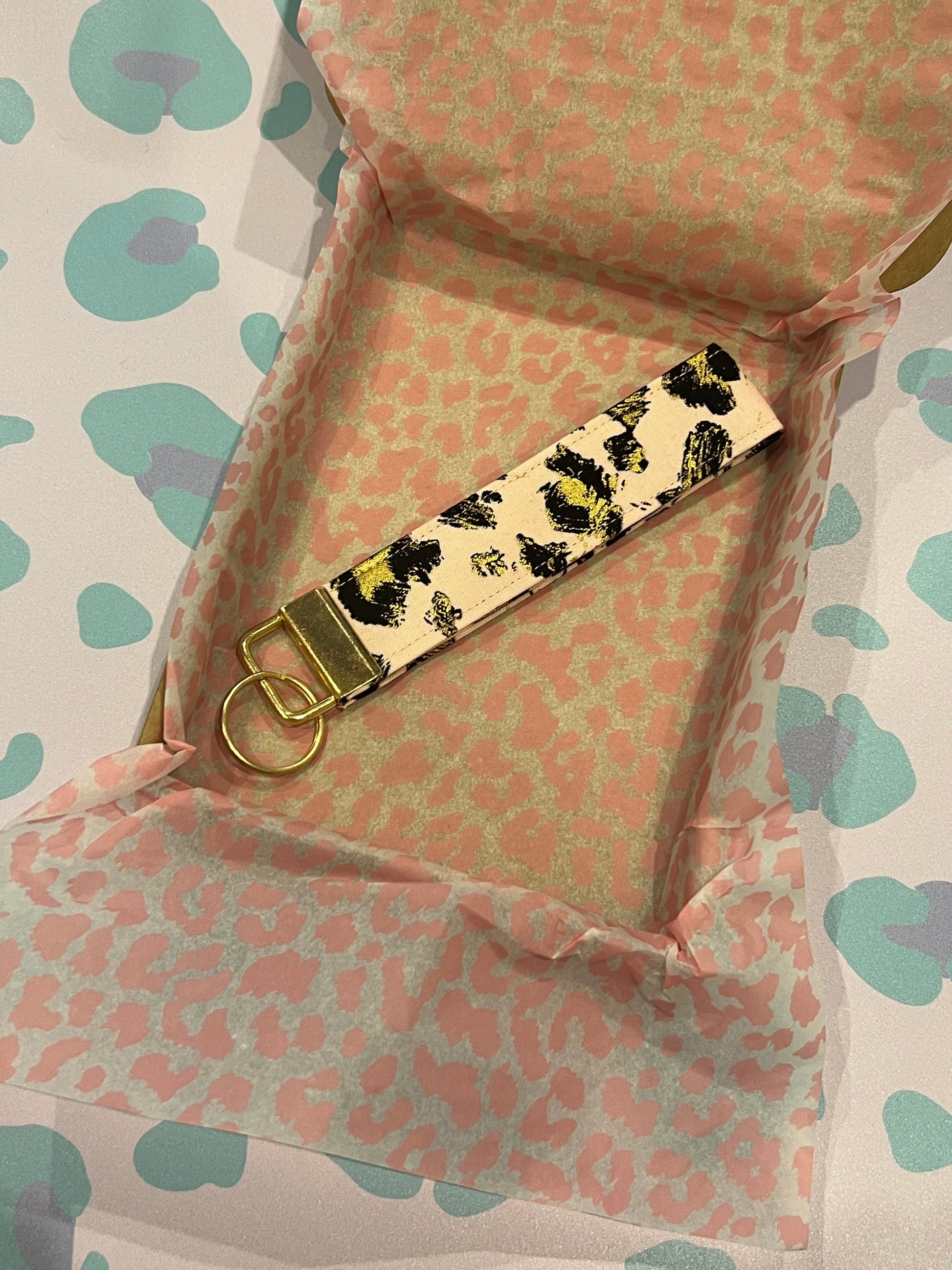 Sew Much Love gold leopard print cotton wristlet keychain with gold hardware on a blush background.