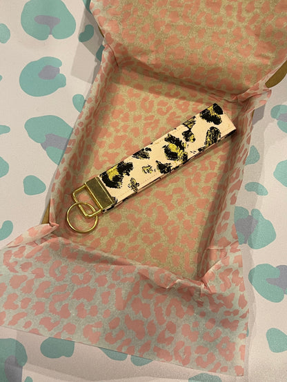 Sew Much Love gold leopard print cotton wristlet keychain with gold hardware on a blush background.