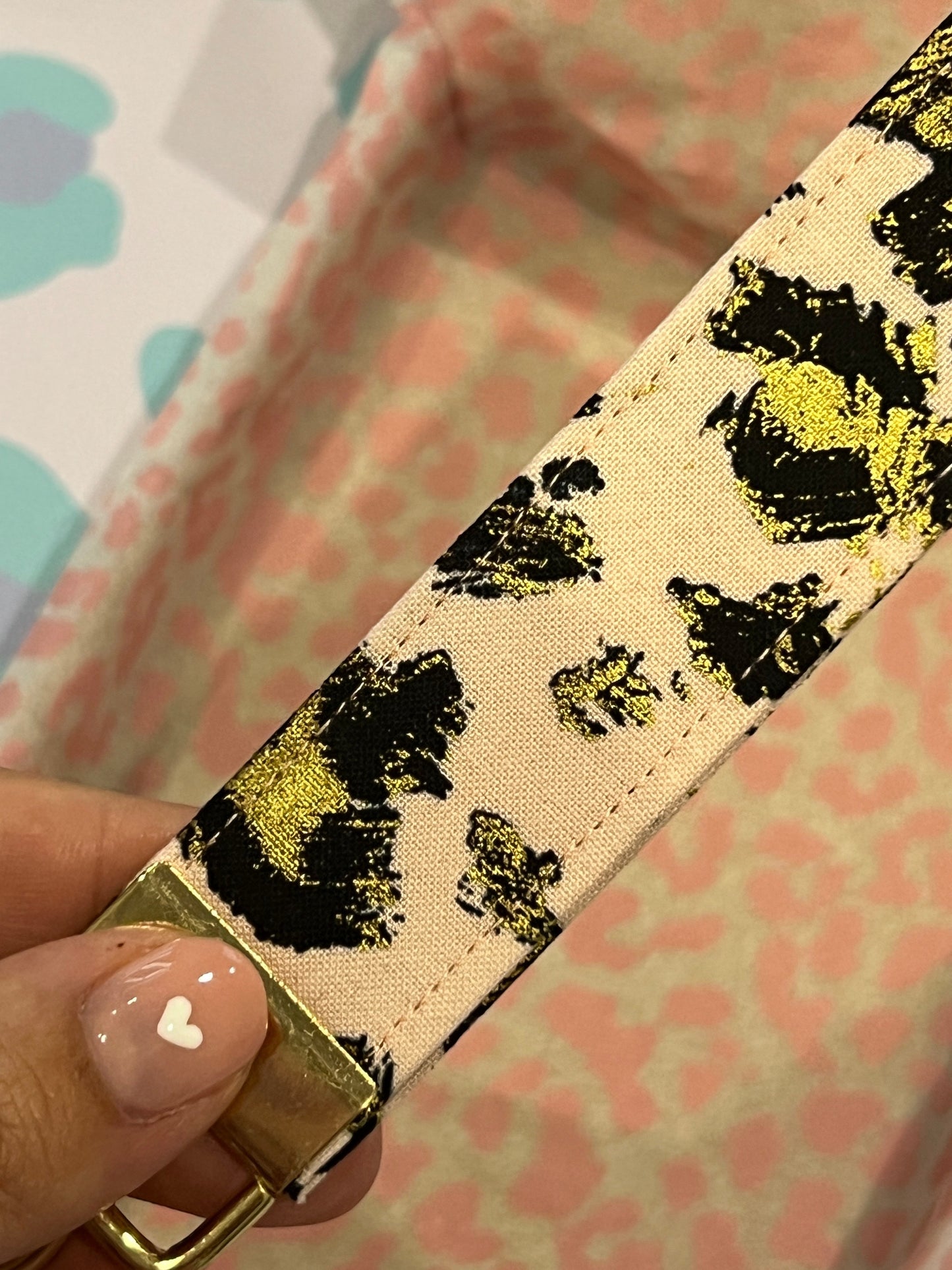 Sew Much Love gold leopard print wristlet keychain on blush pink cotton with gold hardware.