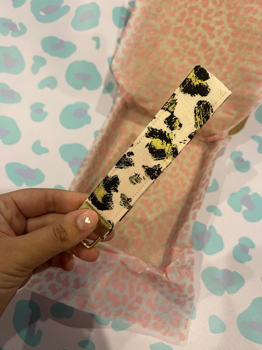 Sew Much Love gold leopard print cotton wristlet keychain on blush pink background with gold hardware.