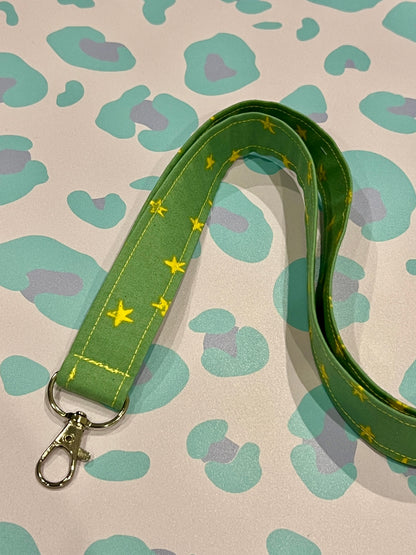Green lanyard with yellow stars on a patterned background