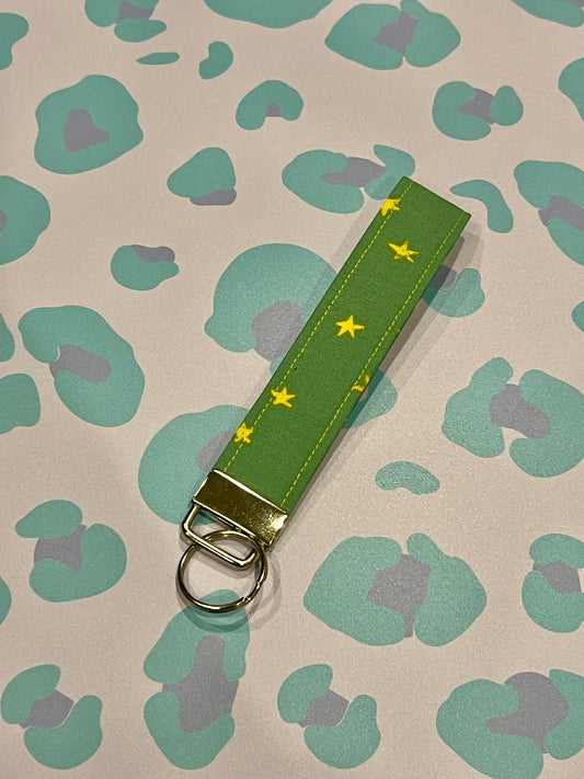 Sew Much Love green fabric wristlet keychain with yellow stars and silver clasp.