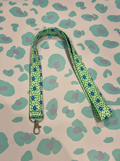 Green floral patterned lanyard on a patterned background