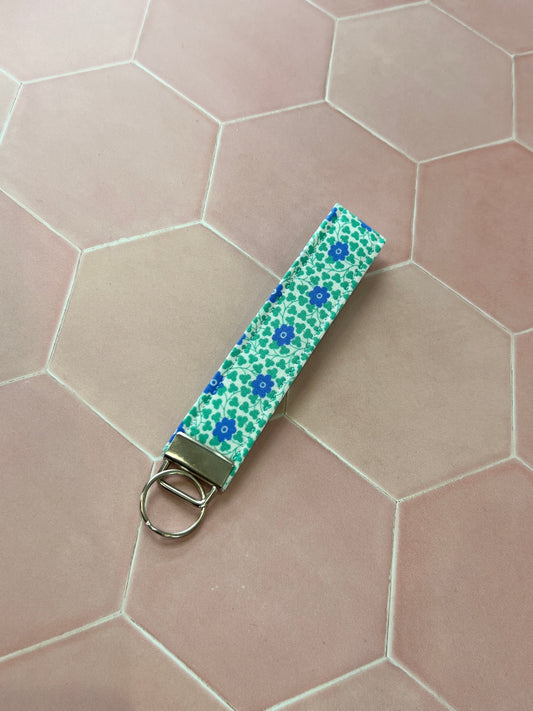 Sew Much Love blue and green floral print cotton wristlet keychain with silver hardware.