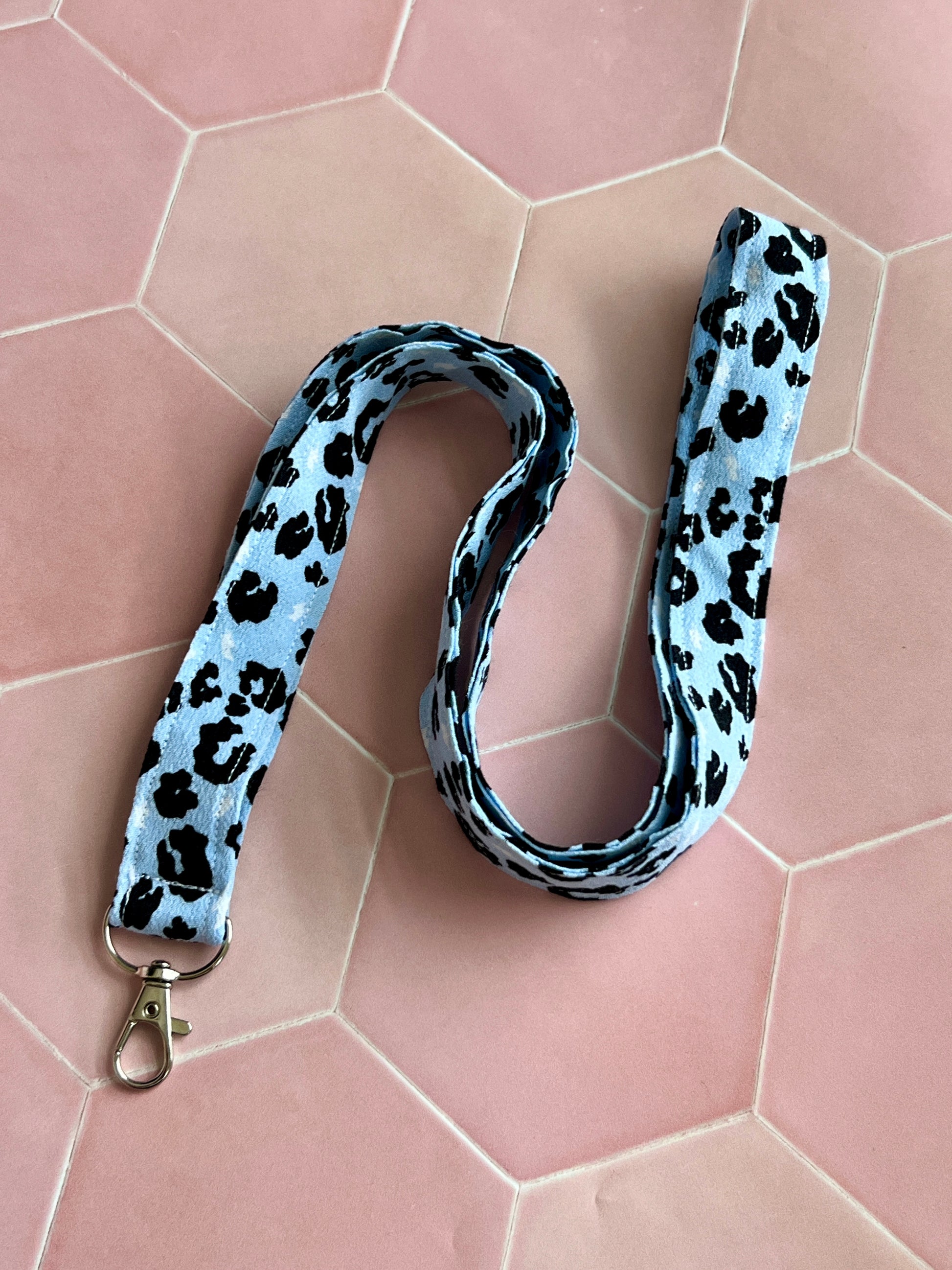 Light blue lanyard with black leopard spots, handmade fabric design with metal D-ring clasp, perfect for everyday essentials