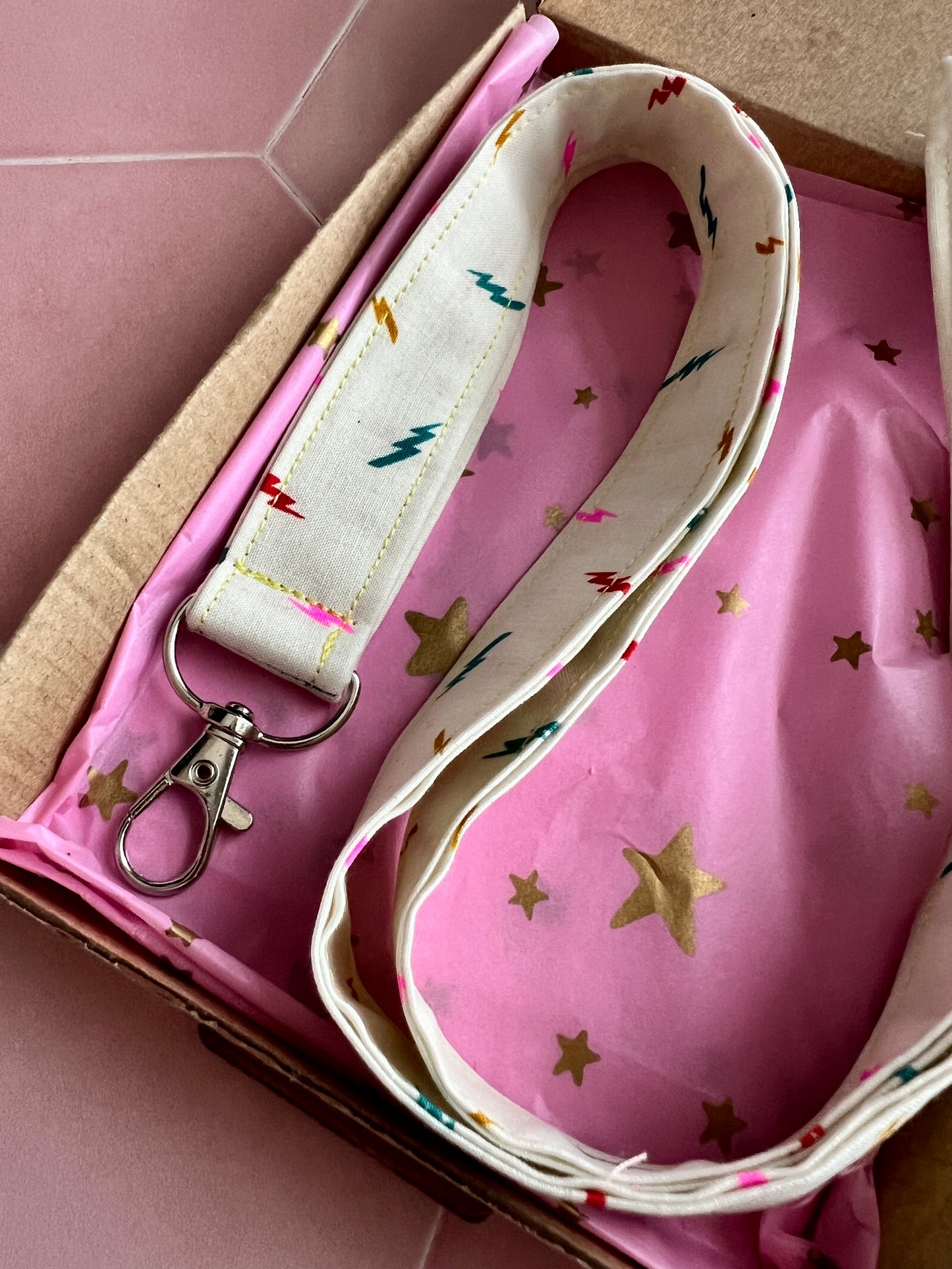 Close-up of colourful lightning bolt handmade lanyard, eco packaging with pink star wrap, ideal teacher or student gift UK