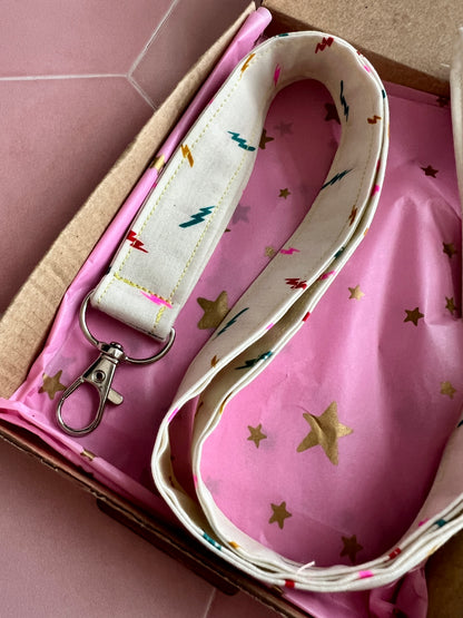 Close-up of colourful lightning bolt handmade lanyard, eco packaging with pink star wrap, ideal teacher or student gift UK