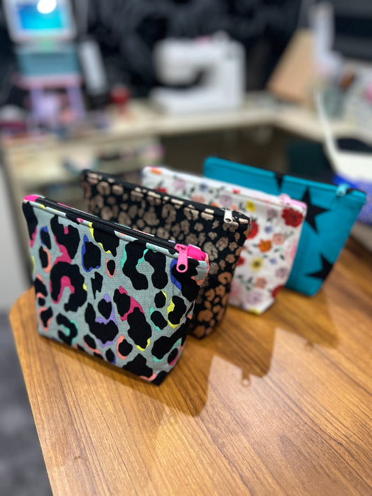 Colourful patterned pouches on a wooden surface with a blurred background