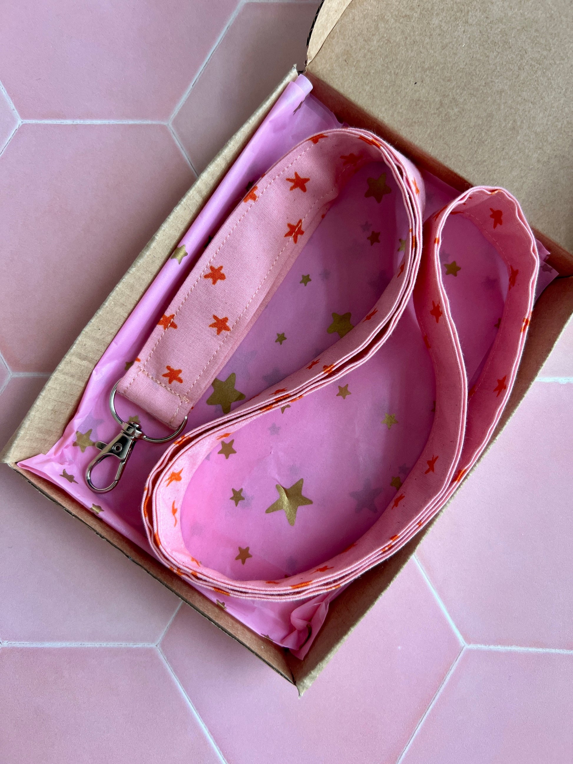 Sew Much Love pink fabric lanyard with orange stars and gold stars lining, featuring a D-ring for keys and ID badges.