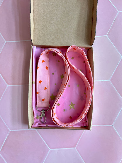 Handmade pink lanyard with orange stars, presented in a kraft gift box lined with pink star printed tissue paper, ideal for everyday essentials