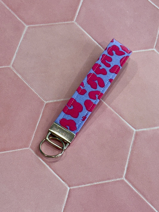 Sew Much Love lilac and pink leopard print fabric wristlet keychain with silver hardware.
