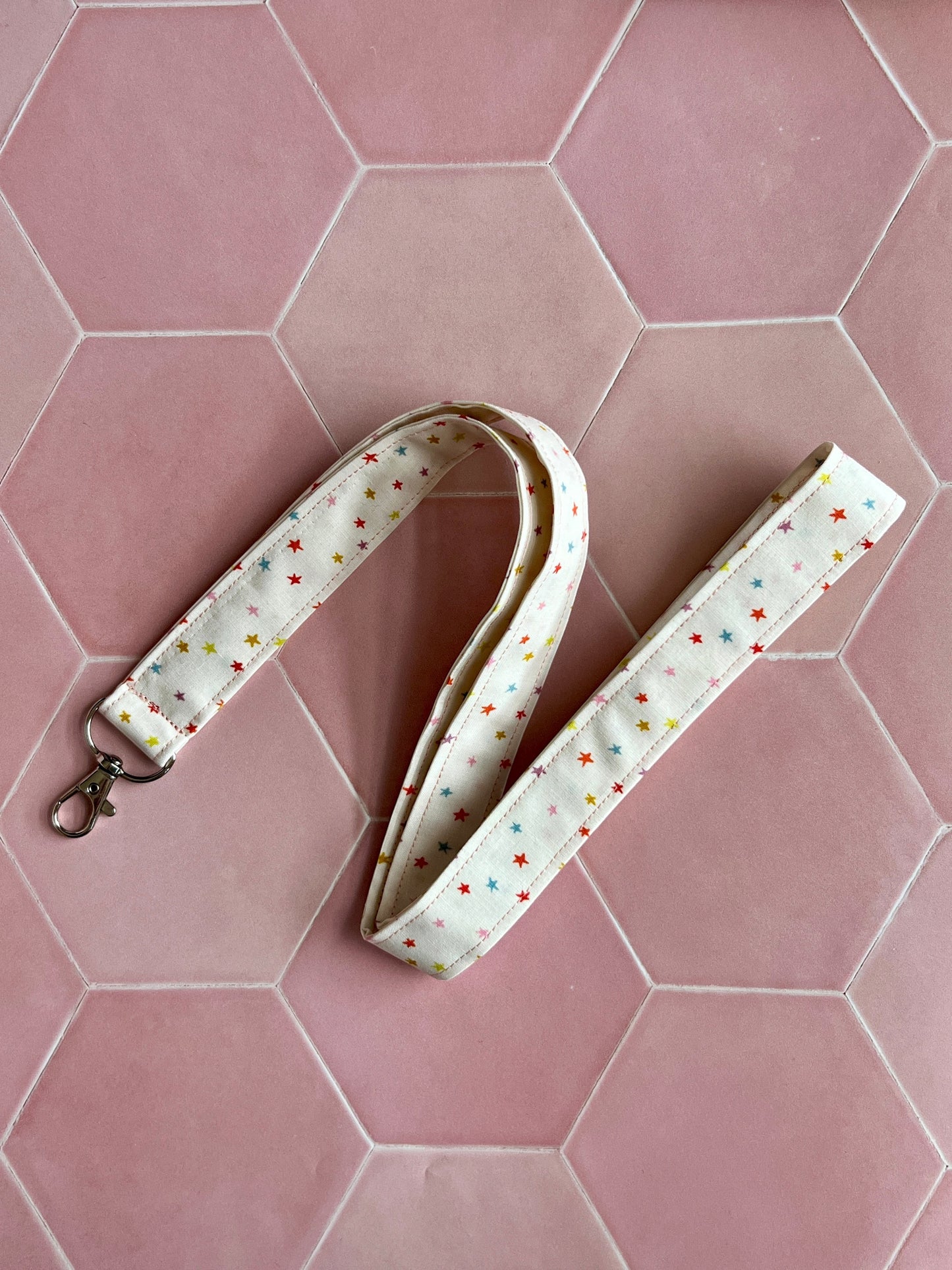 Sew Much Love cream fabric lanyard with multicoloured mini stars and a silver D-ring clasp for keys or ID.