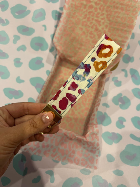 Sew Much Love wristlet with multicolour painterly leopard spots on a cream cotton base and gold hardware.
