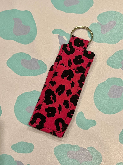 Pink keychain with black leopard print on a patterned background