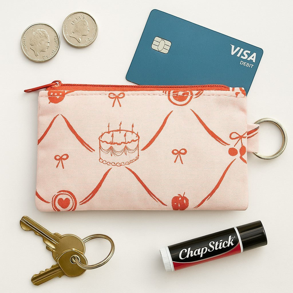 Sew Much Love pink coin purse with red cake, bow, and cherry print. Includes keyring attachment.