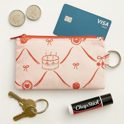 Sew Much Love pink coin purse with red cake, bow, and cherry print. Includes keyring attachment.