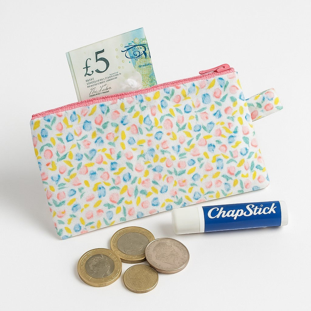 Sew Much Love coin purse with a white background and a pastel tiny tulip print, pink zipper, and keyring tab.