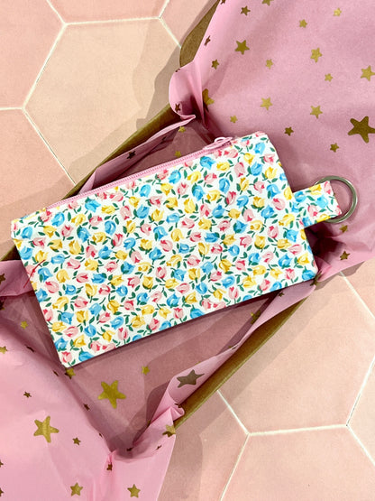 Sew Much Love coin purse with a white base and a tiny tulip print in pastel pink, blue, and yellow. Features a keyring.