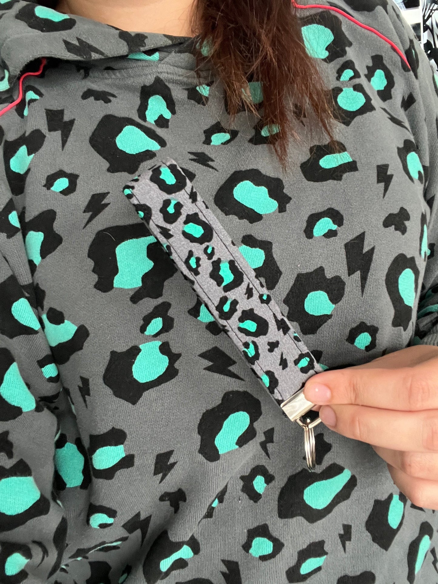 Sew Much Love grey wristlet keychain with black and teal snow leopard print and lightning bolts.