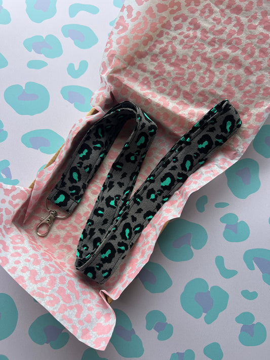 Sew Much Love grey fabric lanyard with black and teal snow leopard print and silver D-ring.