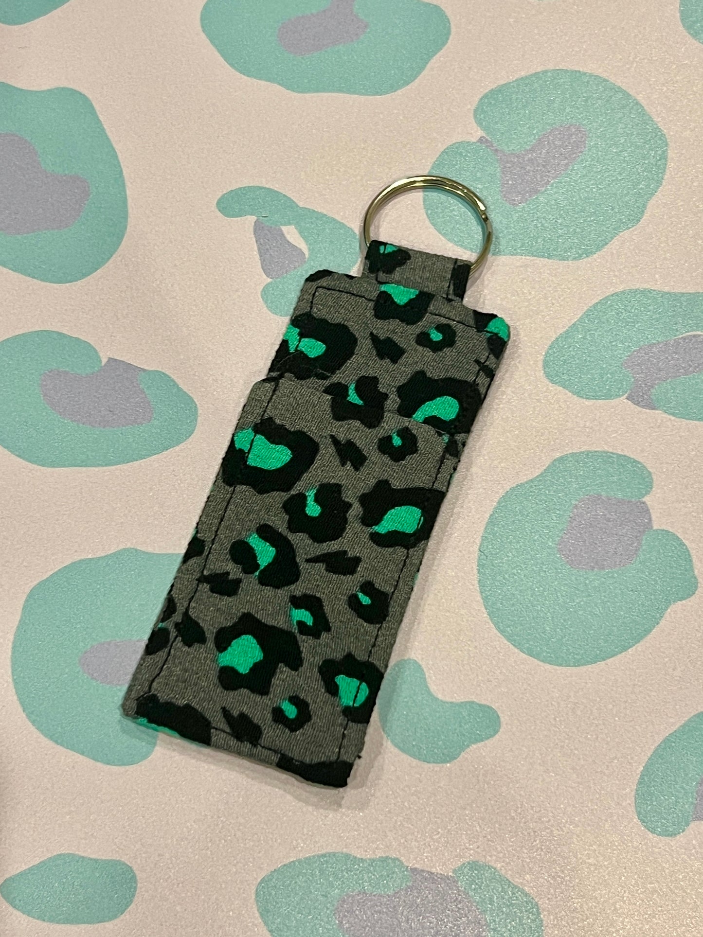 Keychain with leopard print design on a patterned background