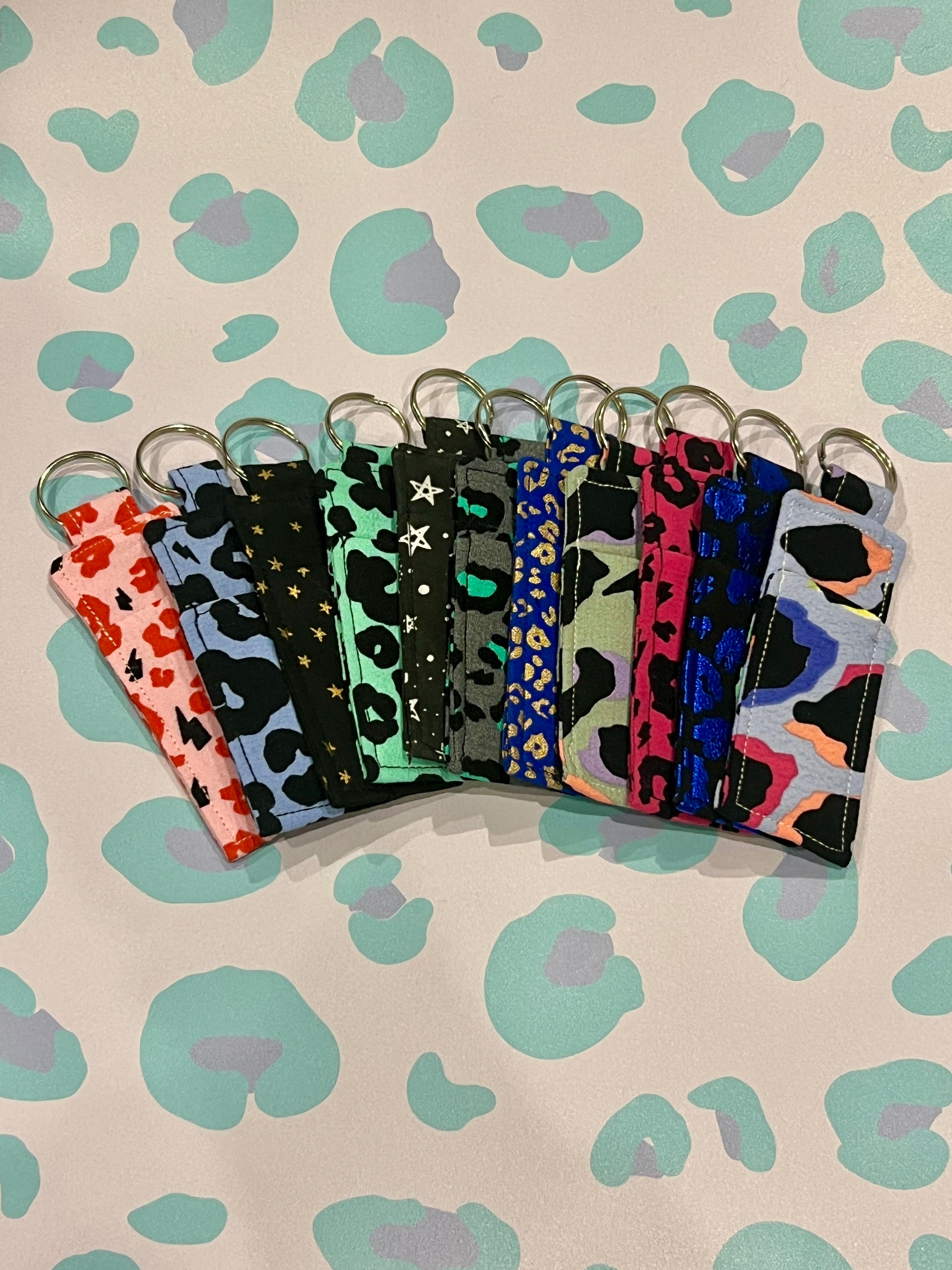 Set of colorful keychains with leopard print patterns on a patterned background