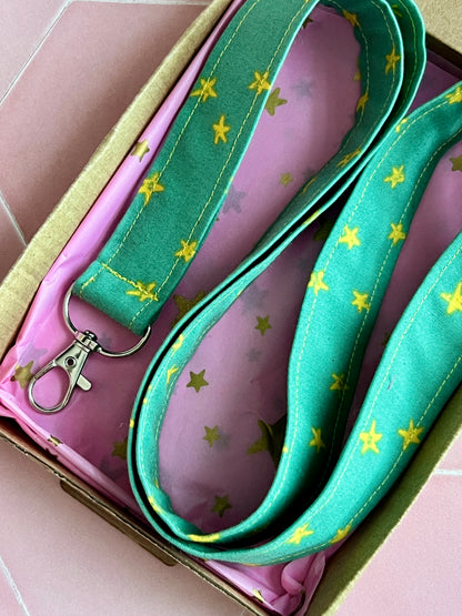 Close-up of handmade green star print lanyard for keys and badges, beautifully packaged in pink star tissue and kraft box