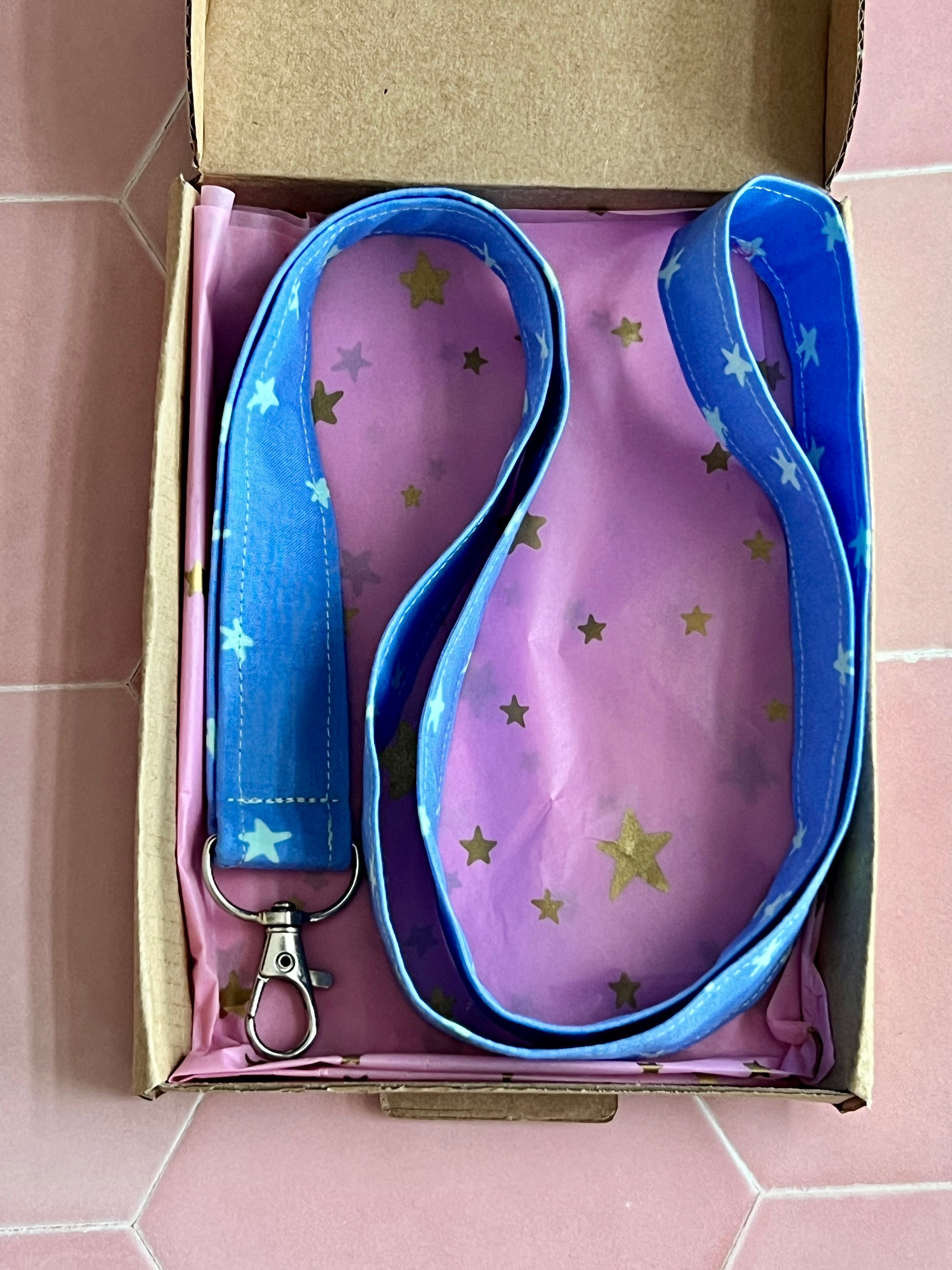 Blue handmade star print lanyard with metal clasp, perfect small business gift, presented in pink star wrapping paper