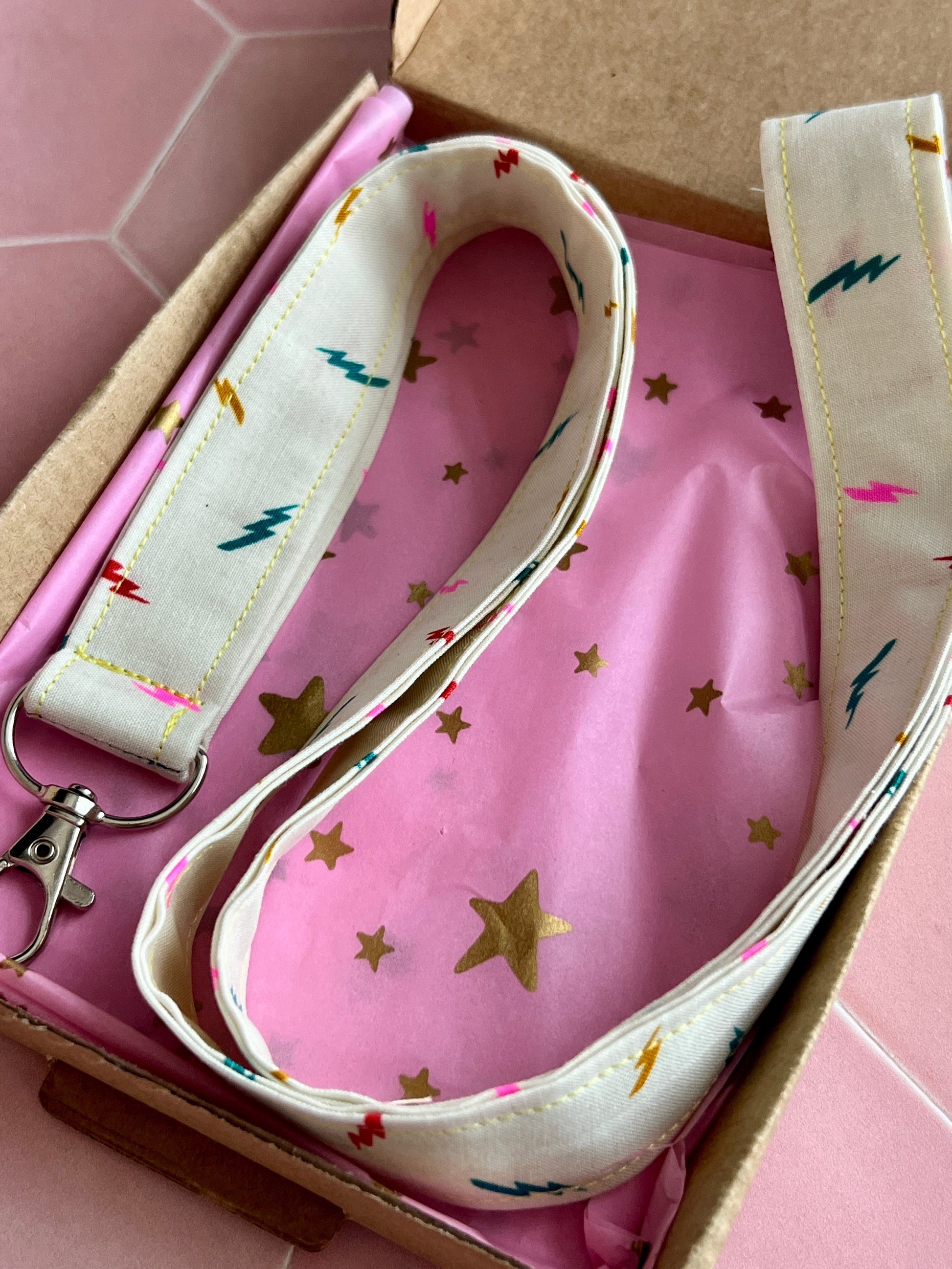 Sew Much Love cream fabric lanyard with colourful lightning bolts and a silver D-ring clasp.