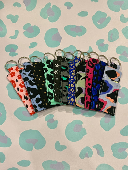 Set of colorful keychains with leopard print patterns on a patterned background