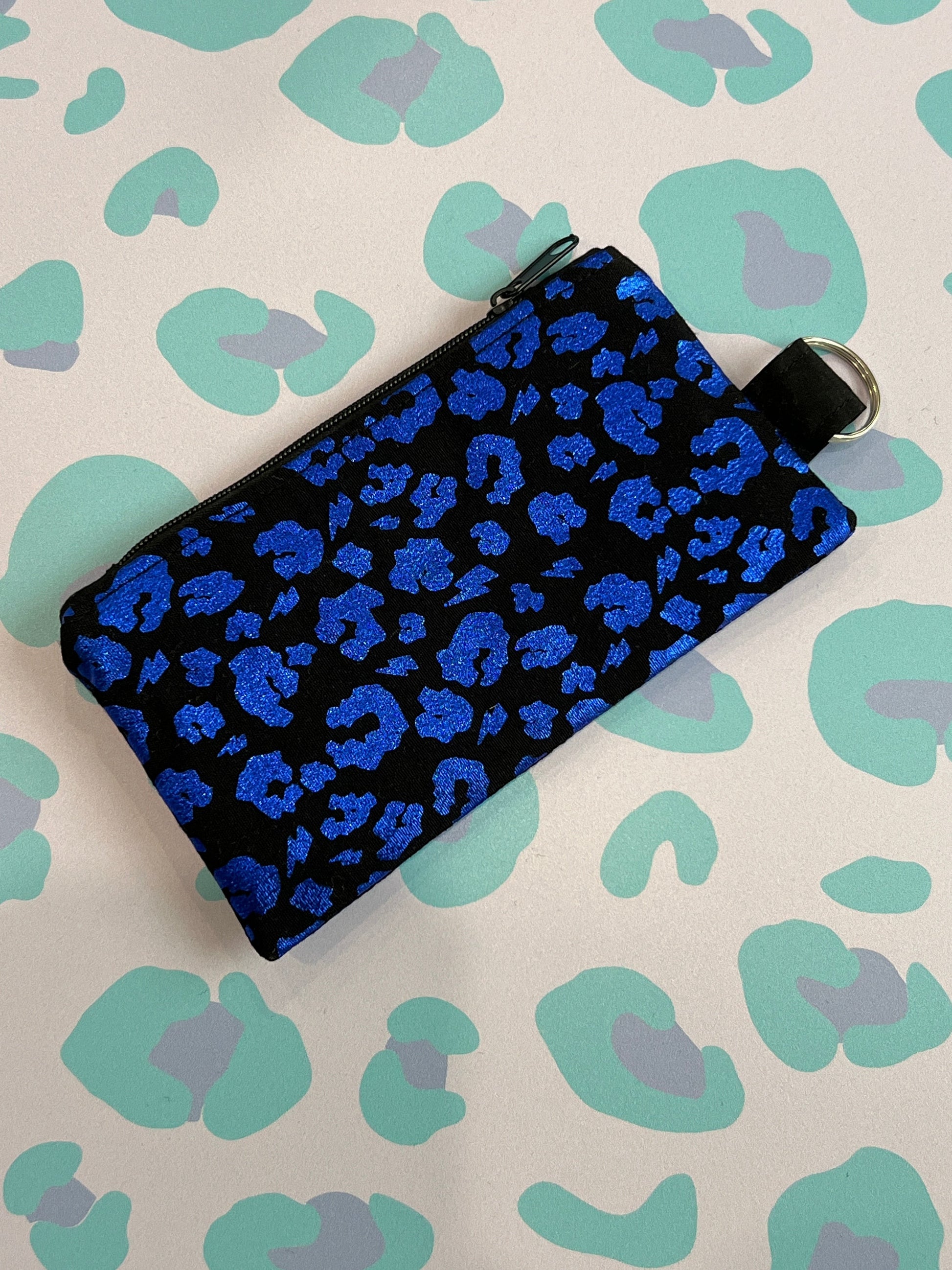 Sew Much Love black coin purse with a vibrant blue leopard print and a keyring attachment.
