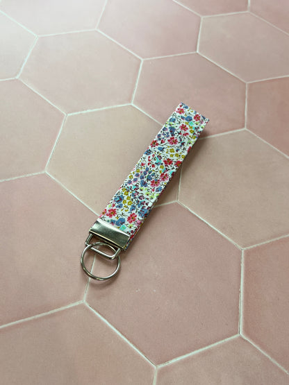 Sew Much Love handmade cotton wristlet keychain with a small floral print in pink, blue, and yellow.
