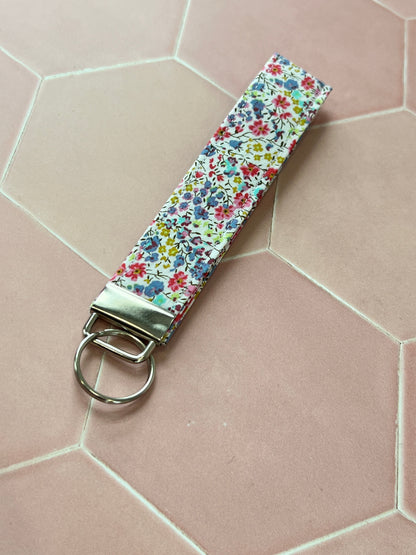 Sew Much Love handmade cotton wristlet keychain with a small floral print in pink, blue, and yellow.