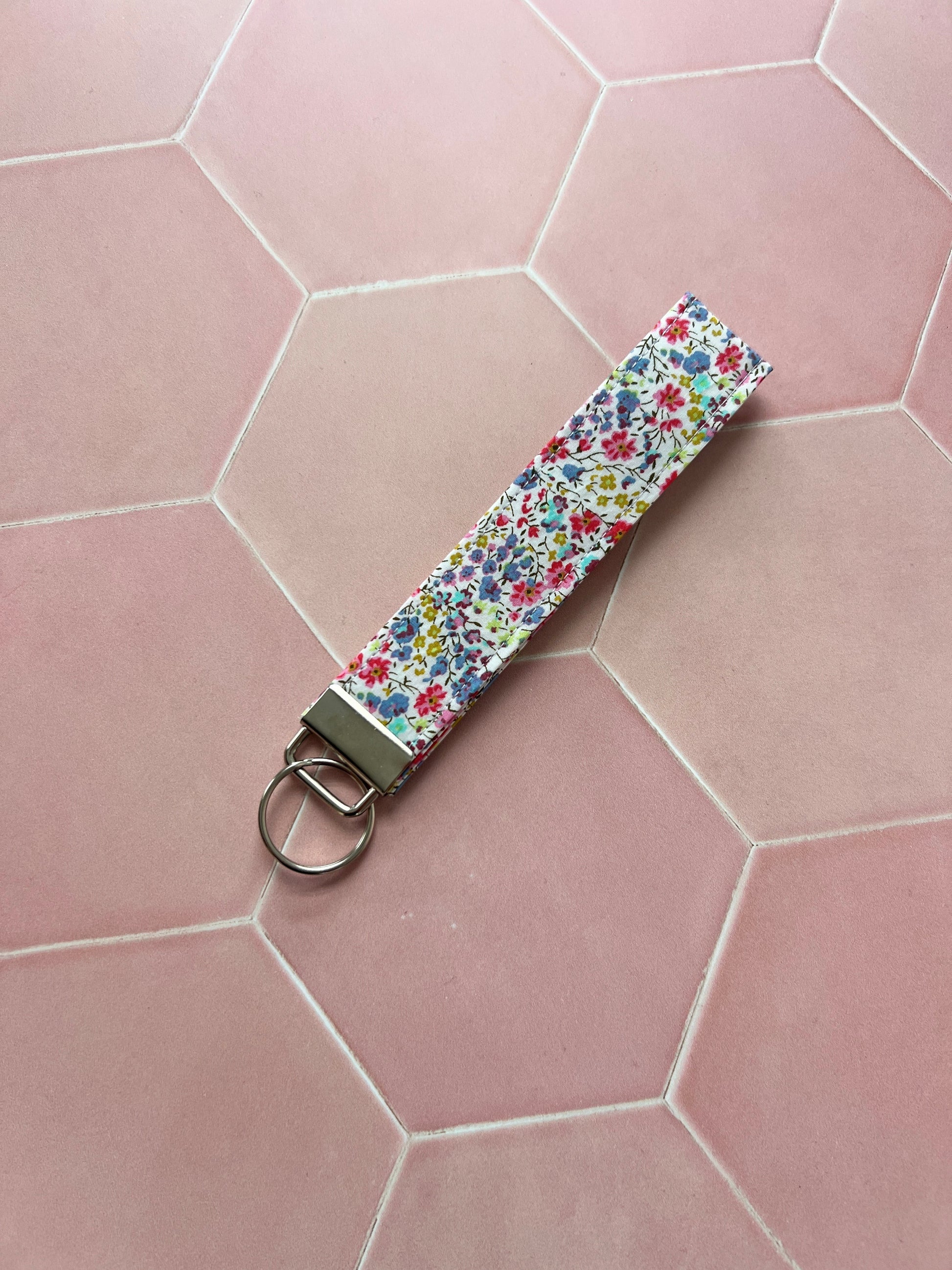 Sew Much Love handmade cotton wristlet keychain with a small floral print in pink, blue, and yellow.