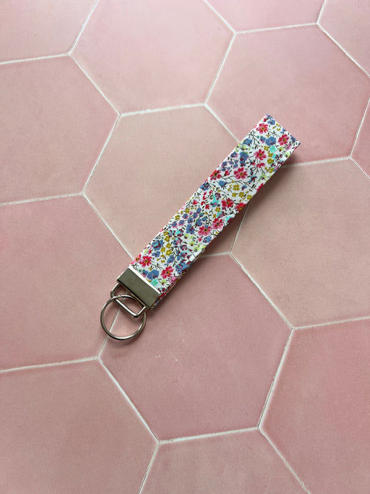 Sew Much Love handmade cotton wristlet keychain with a small floral print in pink, blue, and yellow.