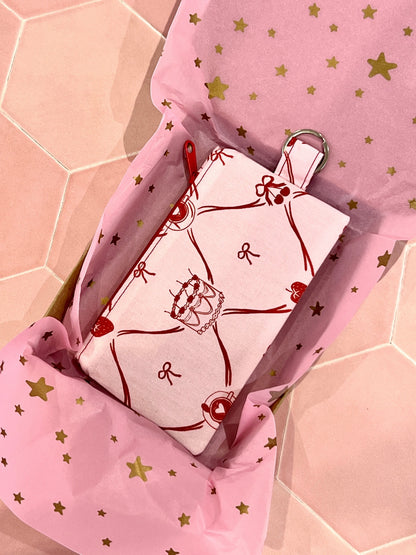 Sew Much Love pink coin purse with red cake, strawberry, and bow print. Features keyring attachment.