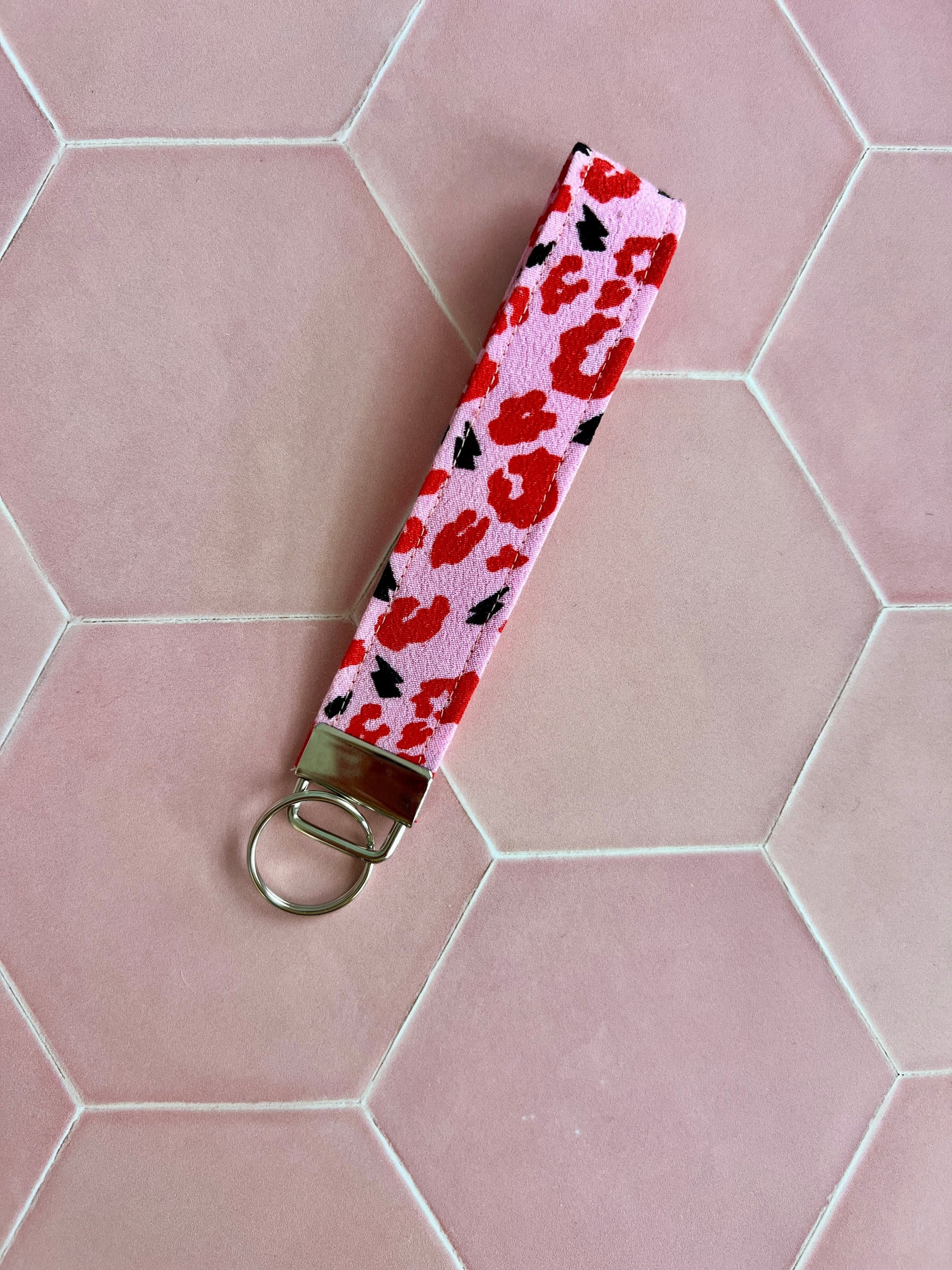 Sew Much Love pink and red leopard print wristlet keychain with black lightning bolts and silver hardware.