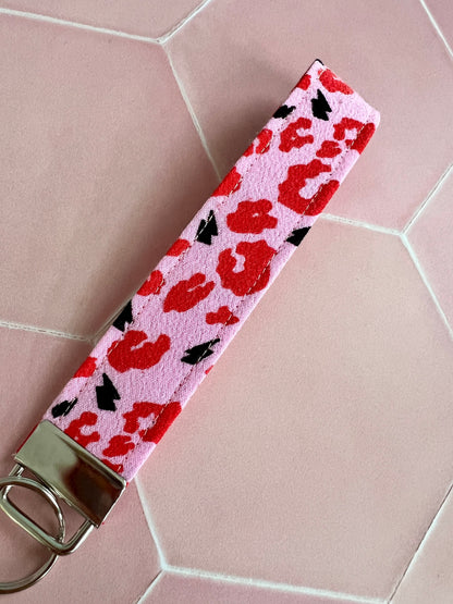 Sew Much Love pink wristlet keychain with red leopard print and black lightning bolts, made from viscose fabric.