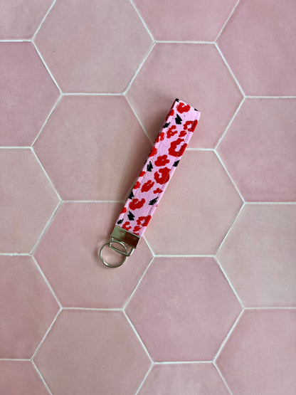Sew Much Love pink and red leopard print wristlet keychain with black lightning bolts and silver hardware.