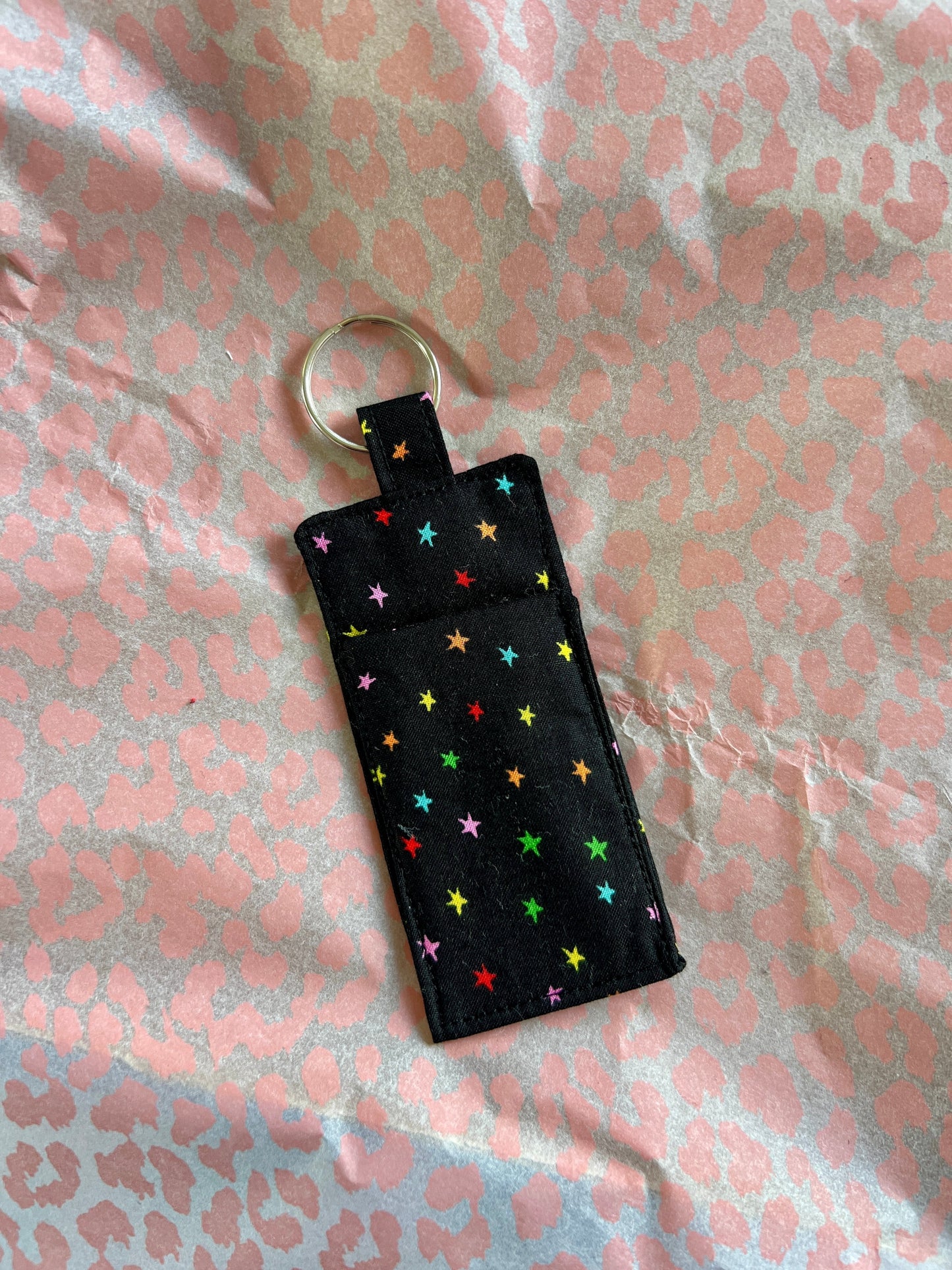 Sew Much Love black cotton lip balm holder with rainbow stars and silver keyring.