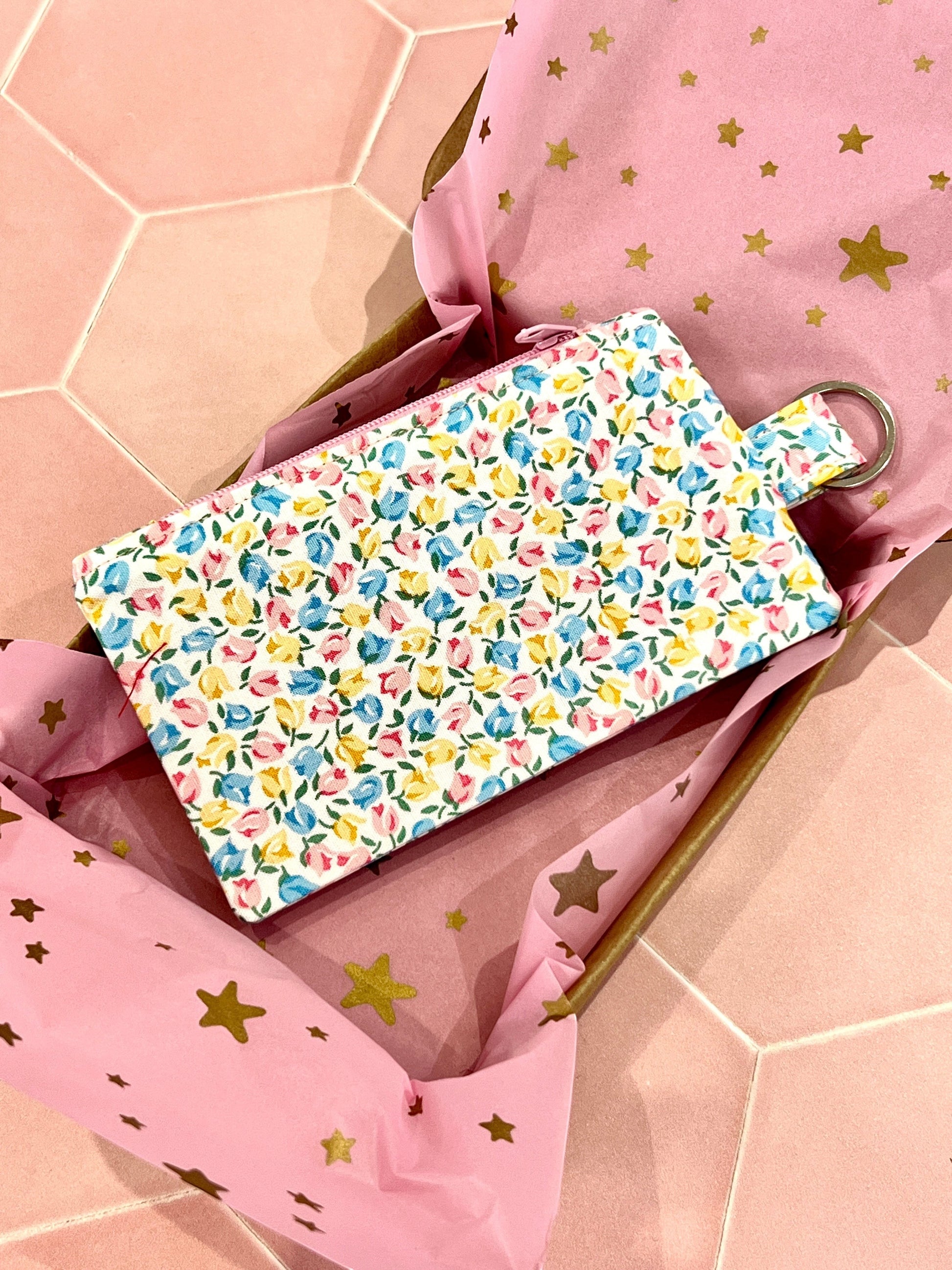 Sew Much Love coin purse with a white base and a tiny floral print in pink, yellow, and blue. Features a keyring attachment.